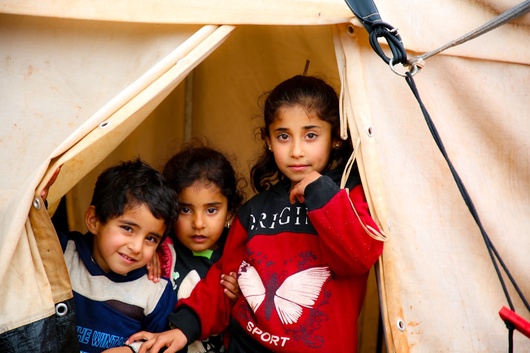 A group of young children standing inside of a tent