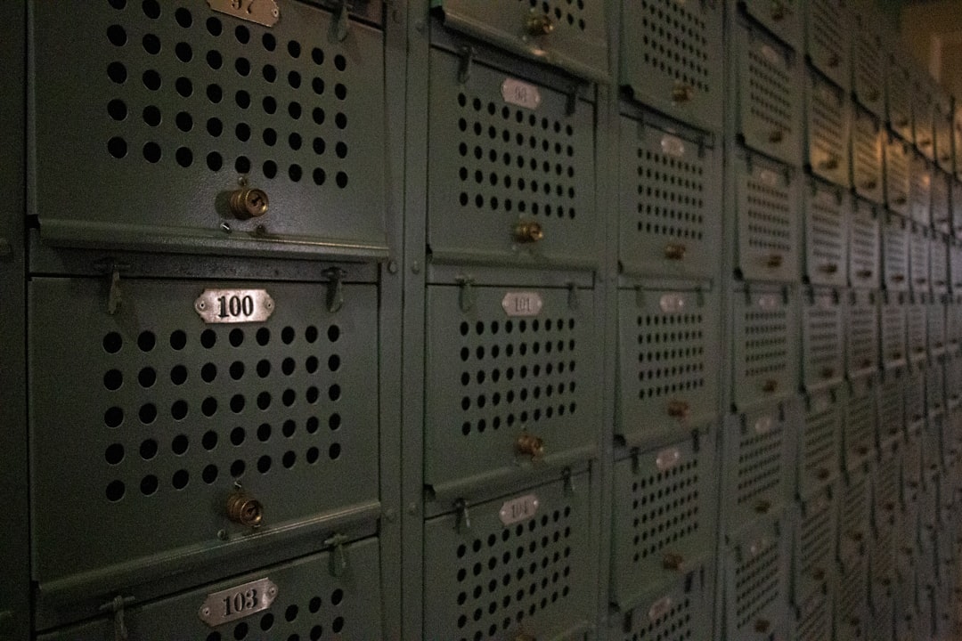 Rows of vintage green lockers with numbered doors.